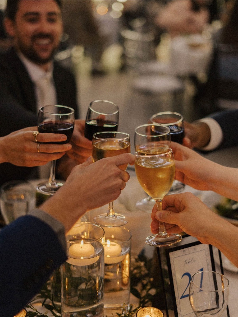 Goście wznoszą toast podczas eleganckiego przyjęcia po weselu