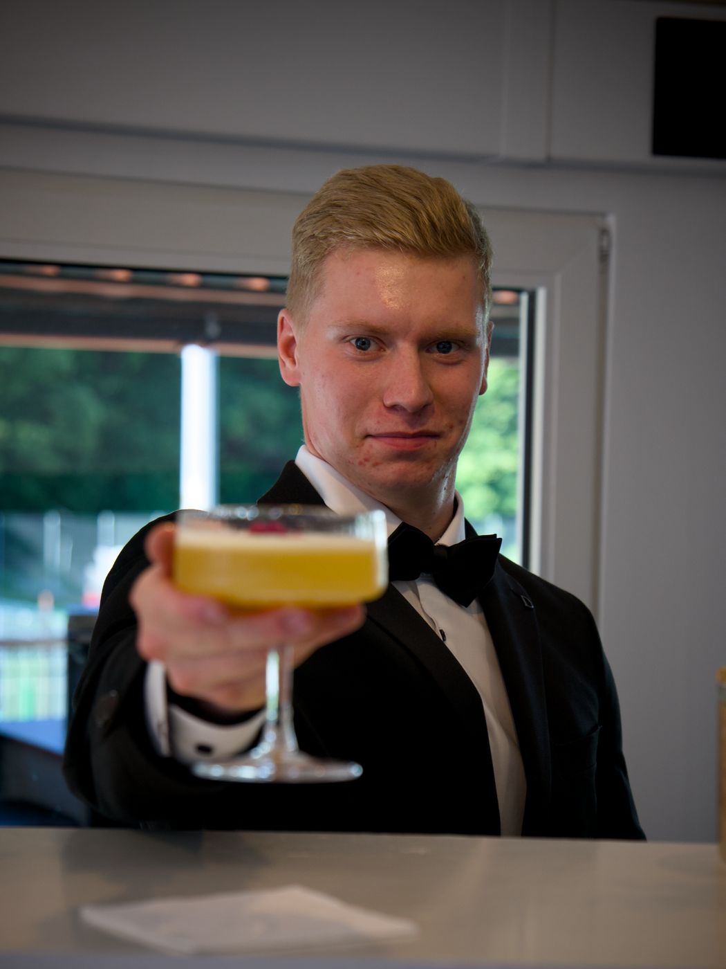 Barman BAROWO podaje koktajl przy białym mobilnym barze